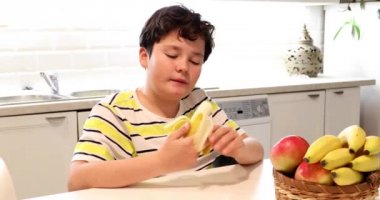 Genç çocuk muz 2 yeme mutfakta oturan