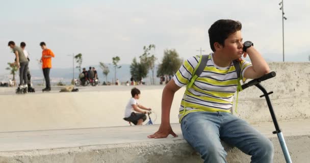 Handsome Unhappy Preteen Boy Scooter Sitting Alone Skateboard Park — Stock Video