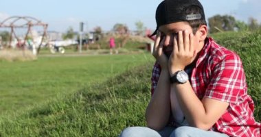 Üzgün preteen çocuk parkta tek başına ağlıyor