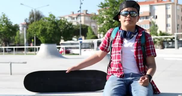 Pré Adolescente Skatista Com Fone Ouvido Sentado Parque Skate — Vídeo de Stock