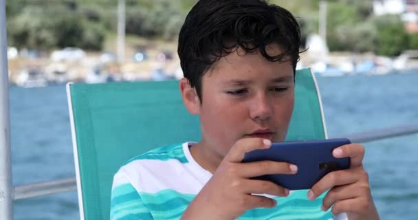 Niño en barco usando teléfono inteligente — Vídeo de stock