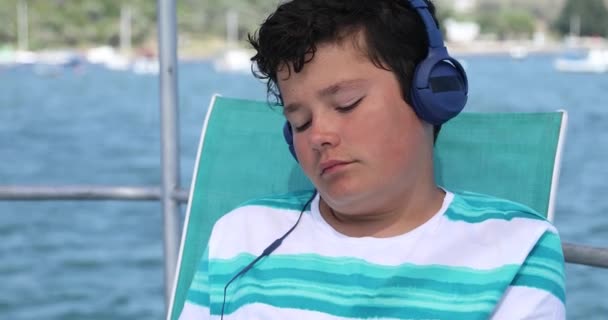 Young boy listening to music and dancing on boat — Stock Video