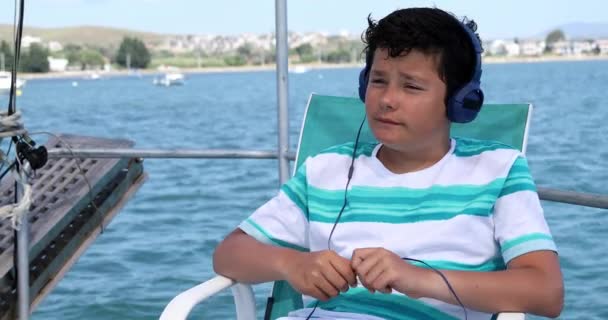 Jeune garçon écoutant de la musique sur le bateau — Video