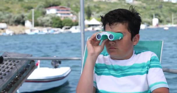 Νεαρό αγόρι στο σκάφος κοιτάζει με κιάλια 2 — Αρχείο Βίντεο
