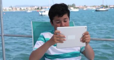 4. yatta dijital tablet bilgisayar kullanan genç bir çocuk.