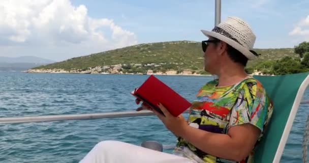 Жінка на човні читає книгу на літніх канікулах 3 — стокове відео