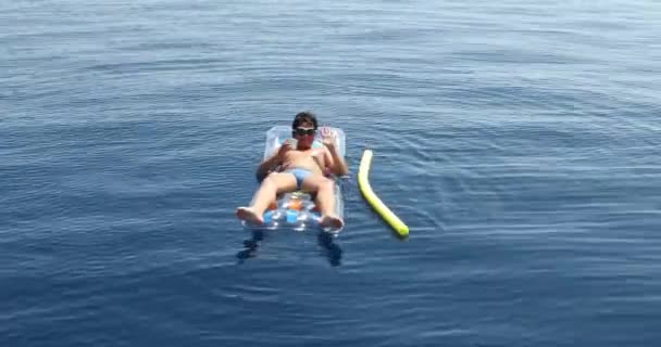 Adolescente chico en el colchón inflable jugando en el mar 4 — Vídeos de Stock