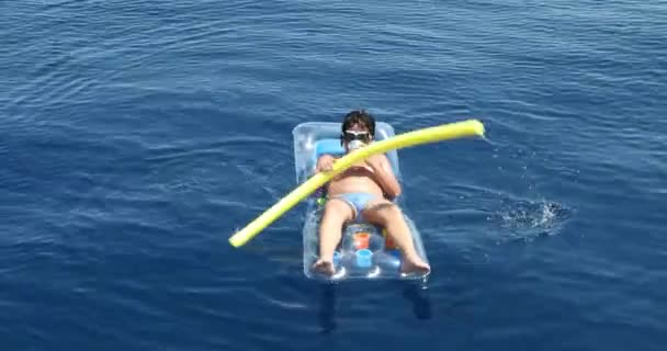 Teenager boy on the inflatable mattress playing on the sea 5 — Stock Video