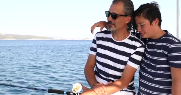 Отец и сын рыбачат на лодке во время летних каникул 5 — стоковое видео