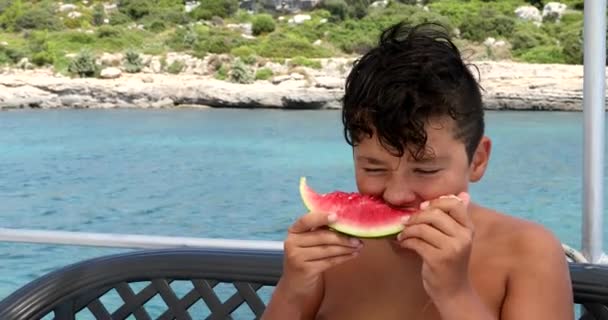 Giovane ragazzo sul ponte yacht mangiare anguria 4 — Video Stock
