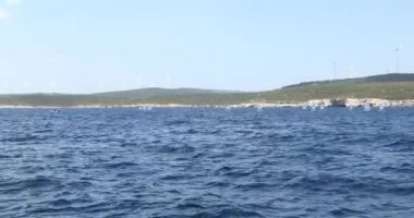 Akdeniz'de yelken civarı öğrenen Optimist yelkenlilerin manzarası