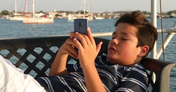 Criança no convés do iate usando smartphone 3 — Vídeo de Stock
