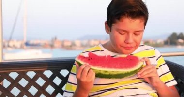 Yat güvertesinde yaz aylarında karpuz yiyen çocuk 2