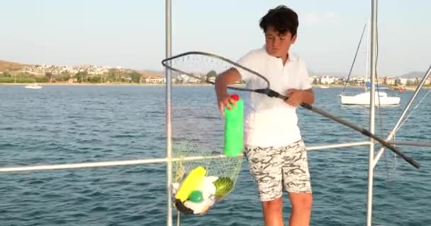 Niño recogiendo botellas de plástico en el mar 7 — Vídeos de Stock