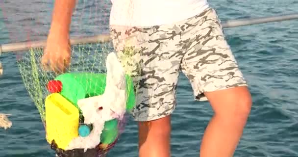 Criança coleta de resíduos de garrafas de plástico no mar 10 — Vídeo de Stock