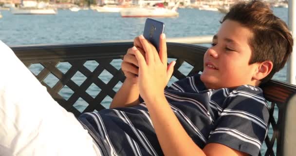 Kind op jacht deck met smartphone 5 — Stockvideo
