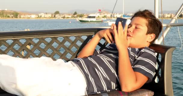 Дитина на яхтній палубі за допомогою смартфона 8 — стокове відео
