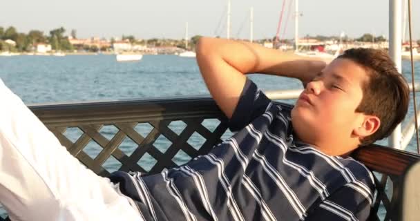 Pohledný dospívající chlapec relaxační na palubě jachty 2 — Stock video