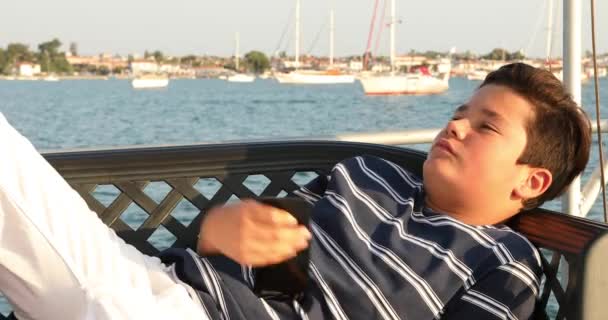 Handsome teenage boy relaxing at the yacht deck — Stock Video