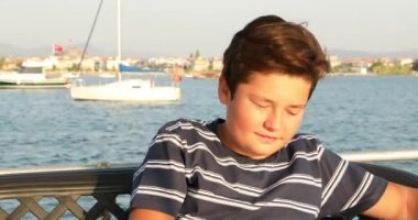 Yaz tatilinde telefon 2 ile selfie fotoğrafı çeken genç çocuk