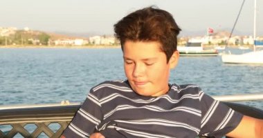 Yaz tatilinde telefon 3 ile selfie fotoğrafı çeken genç çocuk