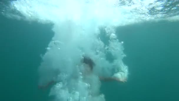 Happy young boy jumping into the sea at sunny summer day — Stock Video