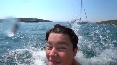 Mutlu genç çocuk güneşli yaz gününde tekne denize atlama 3