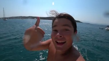 Mutlu genç çocuk güneşli yaz gününde tekne denize atlama 5