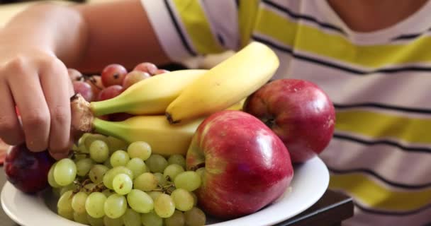 Menino com diferentes tipos de prato de frutas 2 — Vídeo de Stock