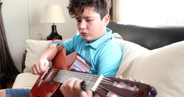 Jonge jongen speelt klassieke gitaar thuis 6 — Stockvideo