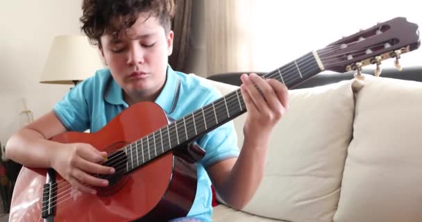 Mladý chlapec hraje klasickou kytaru doma 4 — Stock video