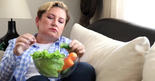 Retrato de una mujer comiendo alimentos frescos y viendo la televisión en casa 3 — Vídeo de stock