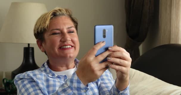Šťastná žena video volání na chytrý telefon doma — Stock video