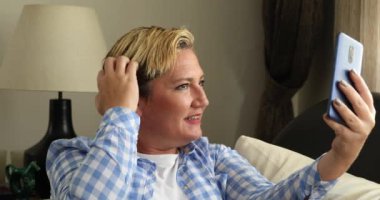 Gülümseyen kadın 2 numarada selfie çekiyor.