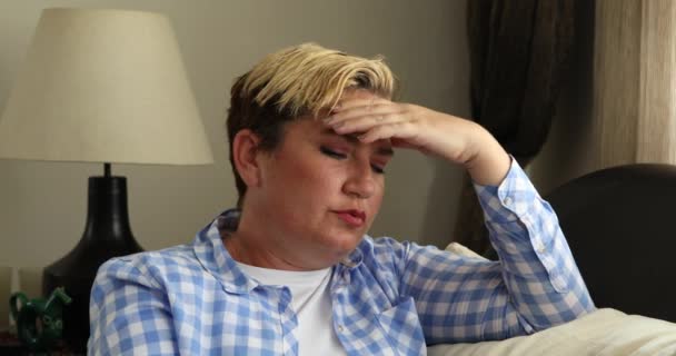 迷人的中年妇女 独自坐在沙发上 患有偏头痛 — 图库视频影像