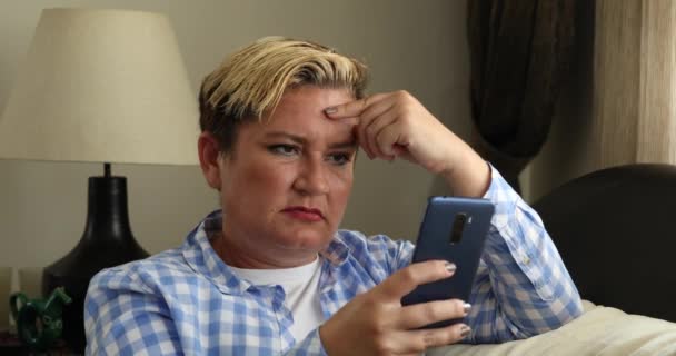 Frau sitzt auf Sofa und benutzt Smartphone zu Hause 3 — Stockvideo