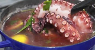 Limon ve maydanozla tencerede pişen büyük ahtapot.