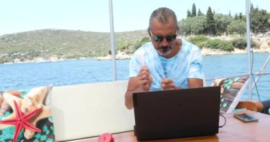 Lüks yattaki beyaz bir turistin portresi yaz tatilinde müzikle rahatlıyor.