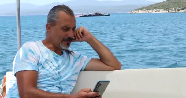 Retrato Homem Meia Idade Está Sentado Convés Iate Com Smartphone — Vídeo de Stock