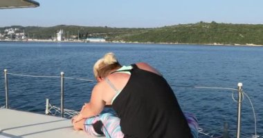 Yaz tatili boyunca yat güvertesinde uzayan sporcu kadınlar.