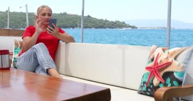 Yaz tatili boyunca cep telefonuyla konuşan kadın.