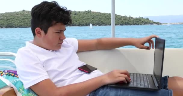 用手提电脑在游艇甲板上的小男孩 — 图库视频影像