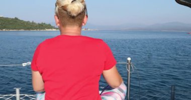 Beyaz kadın turist portresi lüks bir yatta dinleniyor ve yaz tatilinde etrafa bakınıyor.