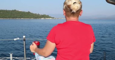 Beyaz kadın turist portresi lüks bir yatta dinleniyor ve yaz tatilinde etrafa bakınıyor.
