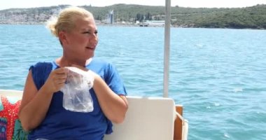 Tekne gezisi sırasında orta yaşlı bir kadının midesi bulanıyor.