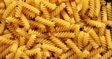 Tabakta dönen fusilli makarna yığını.