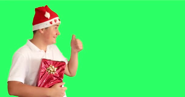 若いです男の子とともにクリスマスプレゼント笑顔と表示Thubsアップで緑の画面の背景 — ストック動画