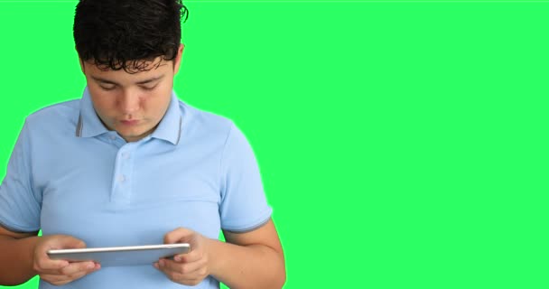 Menino Jovem Contra Backgroud Verde Usando Computador Tablet Digital — Vídeo de Stock