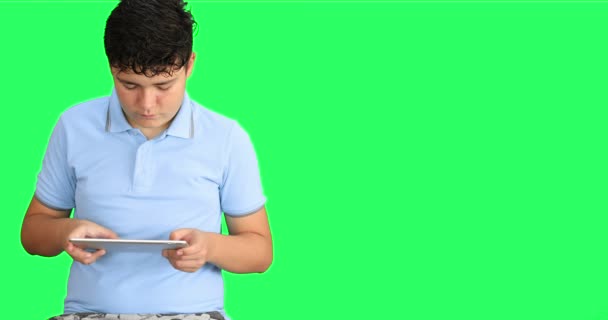 Mladý Chlapec Proti Zelenému Pozadí Pomocí Digitálního Tabletu Počítače — Stock video