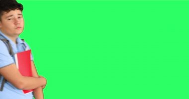 Yeşil ekranda yürüyen sırt çantalı üzgün bir okul çocuğu.